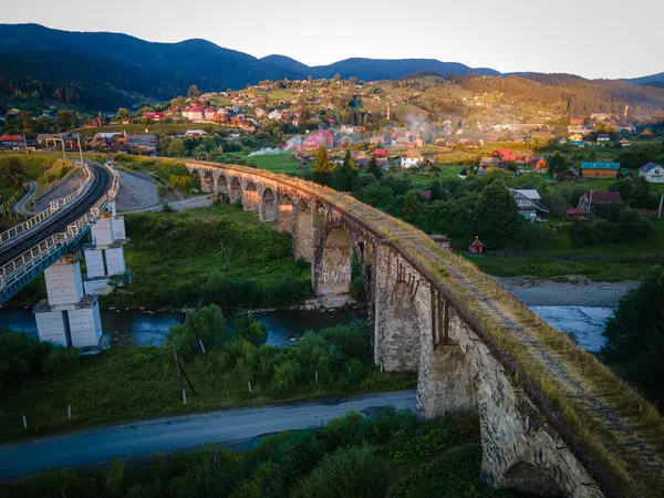 Vorohta, Vorokhta 'nın Alp köyü, antik Avusturya' da anıtsal klasik kemerlere sahip bir dizi köprüdür. Fırtına ve yağmur dağların üzerinde güzel bir gökkuşağı oluşturur..