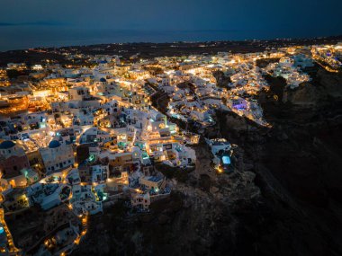 Oia, Santorini 'nin beyazlatılmış köyünün nefes kesici hava manzarası, Ege Denizi' ne bakan sonsuz havuzlu lüks tatil beldelerini gösteriyor. Kiklad mimarisinin çarpıcı bir karışımı.
