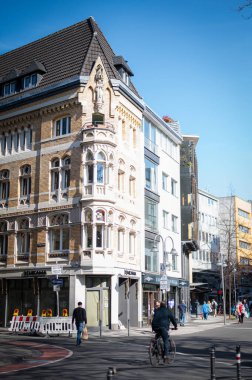 COLOGNE, GERMANY - 7 Mart 2025 Köln sokaklarından hareketli bir manzara, insanların şehir merkezinde gezindiği, canlı şehir atmosferinin, yerel dükkanların, ikonik mimarinin tadını çıkardığı.
