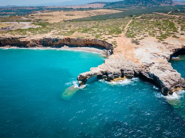 Yunanistan 'ın Girit kentindeki Rethymno şehrinde, ana limandan hemen önce güzel, vahşi bir sahil. Yumuşak dalgalar sıcak güneşin altındaki el değmemiş sahil şeridine yuvarlanarak huzurlu ve manzaralı bir kıyı manzarası yaratıyor.