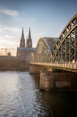 7 Mart 2025. Köln, Almanya. Hohenzollern Köprüsü ile Ren Nehri üzerindeki Katedrale bakın. İnsanlar köprüye gidiyor..