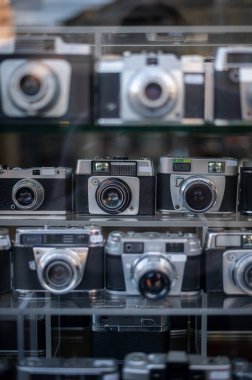 Camların arkasında insanların yansıması ve şehir manzarası olan bulanık, antika kameralar. Evrensel arka plan. Nostalji, fotoğrafçılık, tarih. Yüksek kalite fotoğraf