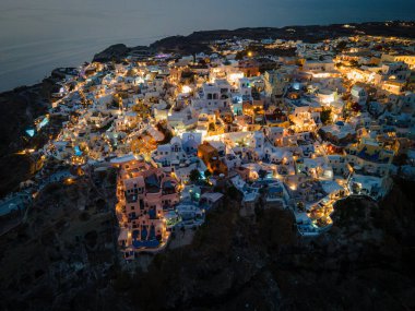 Oia, Santorini 'nin beyazlatılmış köyünün nefes kesici hava manzarası, Ege Denizi' ne bakan sonsuz havuzlu lüks tatil beldelerini gösteriyor. Kiklad mimarisinin çarpıcı bir karışımı.