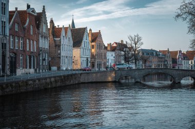 Bruges 'ün dingin kanalları altın saat boyunca şehrin büyüleyici tarihi mimarisini yansıtıyor. Eski kasabanın kalbinde nefes kesici bir bahar akşamı, ılık günbatımı renkleriyle yıkanmış.
