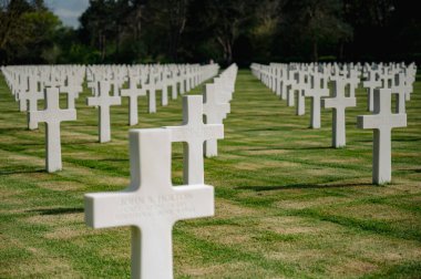 Colleville-sur-Mer, Fransa - 9 Nisan 2025: Omaha Sahili yakınlarındaki Colleville-sur-Mer 'deki Amerikan Mezarlığı' nın resmi manzarası. Beyaz haç sıraları manikürlü çitler arasında mükemmel bir hizada duruyor..