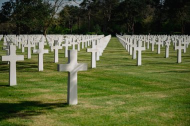 Colleville-sur-Mer, Fransa - 9 Nisan 2025: Omaha Sahili yakınlarındaki Colleville-sur-Mer 'deki Amerikan Mezarlığı' nın resmi manzarası. Beyaz haç sıraları manikürlü çitler arasında mükemmel bir hizada duruyor..