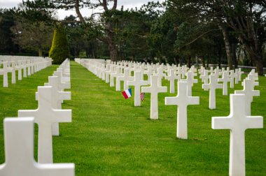 Colleville-sur-Mer, Fransa - 9 Nisan 2025: Omaha Sahili yakınlarındaki Colleville-sur-Mer 'deki Amerikan Mezarlığı' nın resmi manzarası. Beyaz haç sıraları manikürlü çitler arasında mükemmel bir hizada duruyor..