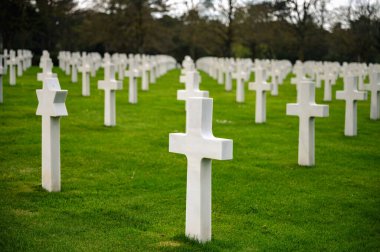 Colleville-sur-Mer, Fransa - 9 Nisan 2025: Omaha Sahili yakınlarındaki Colleville-sur-Mer 'deki Amerikan Mezarlığı' nın resmi manzarası. Beyaz haç sıraları manikürlü çitler arasında mükemmel bir hizada duruyor..