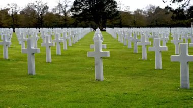 Colleville-sur-Mer, Fransa - 9 Nisan 2025: Omaha Sahili yakınlarındaki Colleville-sur-Mer 'deki Amerikan Mezarlığı' nın resmi manzarası. Beyaz haç sıraları manikürlü çitler arasında mükemmel bir hizada duruyor..