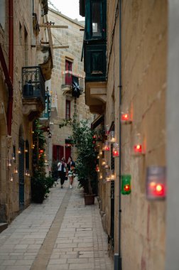 Citta Vittoriosa, Malta - 8 Ekim 2022: Birgufest sırasında mumlarla parlayan antik Citta Vittoriosa caddeleri gibi insanlar Birgu 'nun Candlelight' taki büyülü atmosferinin tadını çıkarıyorlar.