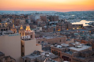 Vallettas 'ın çatılarının çarpıcı hava manzarası, Akdeniz gökyüzünün altındaki tarihi mimari, kubbeler ve kireçtaşı binaları sergiliyor..