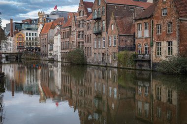 Gent, Belçika 'nın fevkalade bir çekimi. Kanallar boyunca yürüyen, çarpıcı tarihi mimari ve sudaki yansımalarla çevrili insanları gösteriyor..