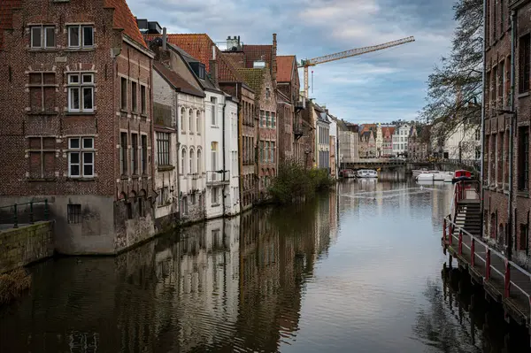 Gent, Belçika 'nın fevkalade bir çekimi. Kanallar boyunca yürüyen, çarpıcı tarihi mimari ve sudaki yansımalarla çevrili insanları gösteriyor..