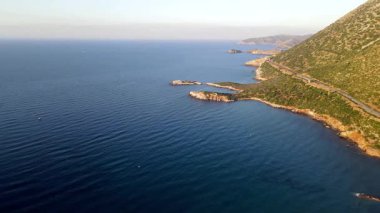 Yunanistan 'ın Girit kentindeki Bali kıyı kasabasında nefes kesici bir güneş doğuyor. Altın ışık denizi ve etrafını saran tepeleri aydınlatarak huzurlu ve resimli bir Akdeniz manzarası yaratır..