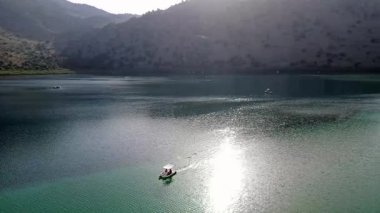 Girit, Georgioupolis yakınlarındaki Kournas Gölü 'nün nefes kesici hava manzarası. Bu drone görüntüsü gölün çarpıcı turkuaz sularını yakalıyor, yemyeşil tepeler ve doğal güzelliklerle çevrili..