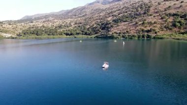 Girit, Georgioupolis yakınlarındaki Kournas Gölü 'nün nefes kesici hava manzarası. Bu drone görüntüsü gölün çarpıcı turkuaz sularını yakalıyor, yemyeşil tepeler ve doğal güzelliklerle çevrili..