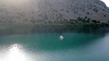 Girit, Georgioupolis yakınlarındaki Kournas Gölü 'nün nefes kesici hava manzarası. Bu drone görüntüsü gölün çarpıcı turkuaz sularını yakalıyor, yemyeşil tepeler ve doğal güzelliklerle çevrili..
