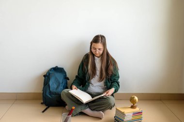 Elinde kitap tutan gülümseyen genç bir öğrenci, temiz beyaz bir arka plana karşı duruyor, okula ya da çalışmaya hazır..