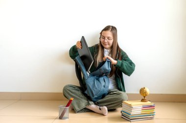 Elinde kitap tutan gülümseyen genç bir öğrenci, temiz beyaz bir arka plana karşı duruyor, okula ya da çalışmaya hazır..