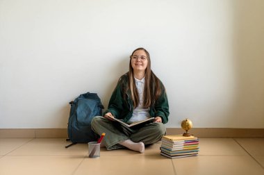 Elinde kitap tutan gülümseyen genç bir öğrenci, temiz beyaz bir arka plana karşı duruyor, okula ya da çalışmaya hazır..