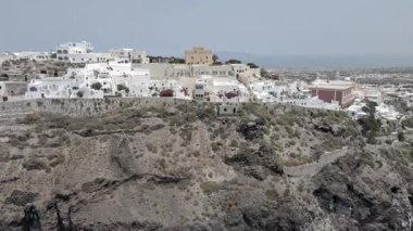 Gündüz vakti Yunanistan 'ın Santorini adasındaki Fira kasabasının nefes kesici manzarası. Beyaz yıkanmış binalar, mavi kubbeli kiliseler ve çarpıcı kaldera manzarası ikonik bir Akdeniz manzarası yaratıyor..