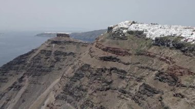 Gündüz vakti Yunanistan 'ın Santorini adasındaki Fira kasabasının nefes kesici manzarası. Beyaz yıkanmış binalar, mavi kubbeli kiliseler ve çarpıcı kaldera manzarası ikonik bir Akdeniz manzarası yaratıyor..