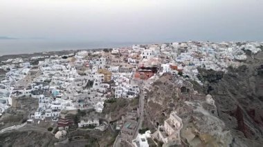 Gündüz vakti Oia, Santorini, Yunanistan 'ın çarpıcı hava manzarası. Beyaz yıkanmış binalar, mavi kubbeler ve nefes kesici kaldera kayalıkları güzel bir Akdeniz manzarası yaratır..