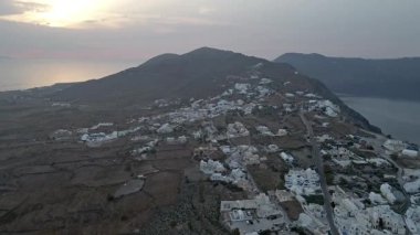 Güneş doğarken Oia, Santorini, Yunanistan 'ın çarpıcı hava manzarası. Beyaz yıkanmış binalar, mavi kubbeler ve nefes kesici kaldera kayalıkları güzel bir Akdeniz manzarası yaratır..