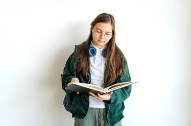 Elinde kitap tutan gülümseyen genç bir öğrenci, temiz beyaz bir arka plana karşı duruyor, okula ya da çalışmaya hazır..