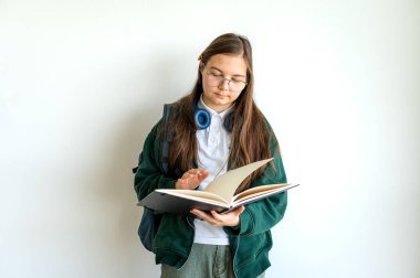 Elinde kitap tutan gülümseyen genç bir öğrenci, temiz beyaz bir arka plana karşı duruyor, okula ya da çalışmaya hazır..