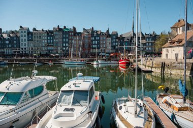 Honfleur 'da yarım ahşap evler, antika dükkanlar ve canlı çiçek sergileriyle dolu pitoresk kaldırımlı bir cadde eski dünya cazibesini yakalıyor.