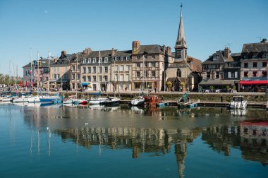 Honfleur 'da yarım ahşap evler, antika dükkanlar ve canlı çiçek sergileriyle dolu pitoresk kaldırımlı bir cadde eski dünya cazibesini yakalıyor.