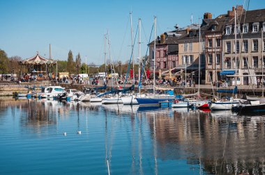 Honfleur 'da yarım ahşap evler, antika dükkanlar ve canlı çiçek sergileriyle dolu pitoresk kaldırımlı bir cadde eski dünya cazibesini yakalıyor.