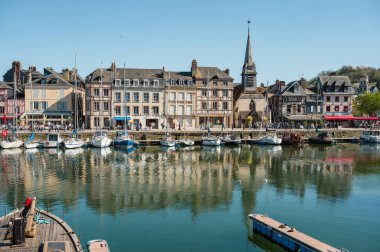 Honfleur 'da yarım ahşap evler, antika dükkanlar ve canlı çiçek sergileriyle dolu pitoresk kaldırımlı bir cadde eski dünya cazibesini yakalıyor.