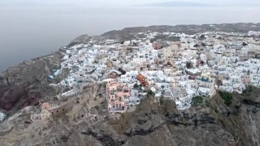 Gündüz vakti Oia, Santorini, Yunanistan 'ın çarpıcı hava manzarası. Beyaz yıkanmış binalar, mavi kubbeler ve nefes kesici kaldera kayalıkları güzel bir Akdeniz manzarası yaratır..