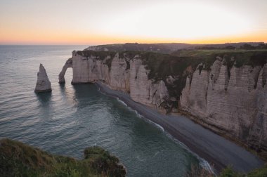 Etretat 'ın ikonik tebeşir kayalıkları ve turkuaz suları güneş ışığı altında parlayarak Normandiya' nın doğal güzelliğini ve huzurlu sahil şeridini gözler önüne seriyor..