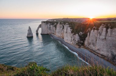 Etretat 'ın ikonik tebeşir kayalıkları ve turkuaz suları güneş ışığı altında parlayarak Normandiya' nın doğal güzelliğini ve huzurlu sahil şeridini gözler önüne seriyor..