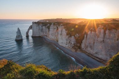Etretat 'ın ikonik tebeşir kayalıkları ve turkuaz suları güneş ışığı altında parlayarak Normandiya' nın doğal güzelliğini ve huzurlu sahil şeridini gözler önüne seriyor..