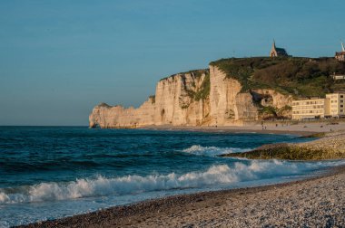 Etretat 'ın ikonik tebeşir kayalıkları ve turkuaz suları güneş ışığı altında parlayarak Normandiya' nın doğal güzelliğini ve huzurlu sahil şeridini gözler önüne seriyor..
