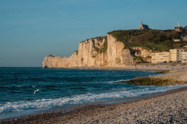 Etretat 'ın ikonik tebeşir kayalıkları ve turkuaz suları güneş ışığı altında parlayarak Normandiya' nın doğal güzelliğini ve huzurlu sahil şeridini gözler önüne seriyor..