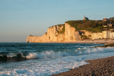 Etretat 'ın ikonik tebeşir kayalıkları ve turkuaz suları güneş ışığı altında parlayarak Normandiya' nın doğal güzelliğini ve huzurlu sahil şeridini gözler önüne seriyor..