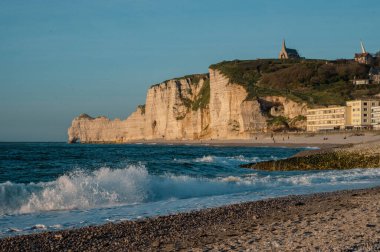 Etretat 'ın ikonik tebeşir kayalıkları ve turkuaz suları güneş ışığı altında parlayarak Normandiya' nın doğal güzelliğini ve huzurlu sahil şeridini gözler önüne seriyor..