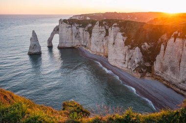 Etretat 'ın ikonik tebeşir kayalıkları ve turkuaz suları güneş ışığı altında parlayarak Normandiya' nın doğal güzelliğini ve huzurlu sahil şeridini gözler önüne seriyor..