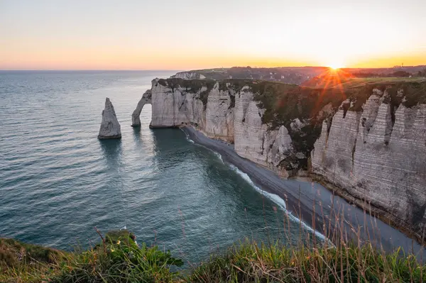 Etretat 'ın ikonik tebeşir kayalıkları ve turkuaz suları güneş ışığı altında parlayarak Normandiya' nın doğal güzelliğini ve huzurlu sahil şeridini gözler önüne seriyor..