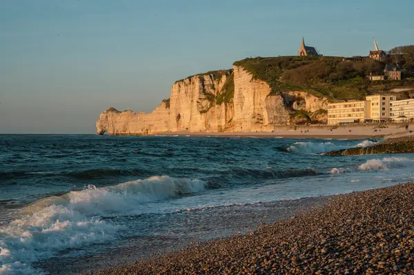 Etretat 'ın ikonik tebeşir kayalıkları ve turkuaz suları güneş ışığı altında parlayarak Normandiya' nın doğal güzelliğini ve huzurlu sahil şeridini gözler önüne seriyor..