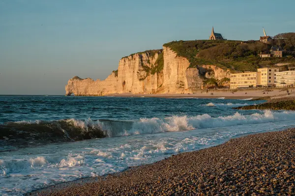 Etretat 'ın ikonik tebeşir kayalıkları ve turkuaz suları güneş ışığı altında parlayarak Normandiya' nın doğal güzelliğini ve huzurlu sahil şeridini gözler önüne seriyor..