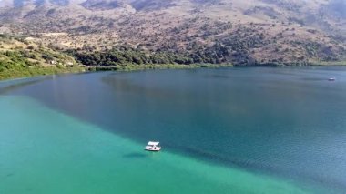 Girit, Georgioupolis yakınlarındaki Kournas Gölü 'nün nefes kesici hava manzarası. Bu yukarıdan aşağıya insansız hava aracı görüntüsü, yemyeşil tepeler ve doğal güzelliklerle çevrili, büyüleyici turkuaz suları yakalıyor..