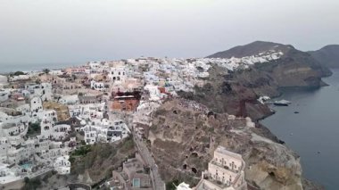 Gündüz vakti Oia, Santorini, Yunanistan 'ın çarpıcı hava manzarası. Beyaz yıkanmış binalar, mavi kubbeler ve nefes kesici kaldera kayalıkları güzel bir Akdeniz manzarası yaratır..