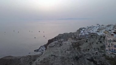Gündüz vakti Oia, Santorini, Yunanistan 'ın çarpıcı hava manzarası. Beyaz yıkanmış binalar, mavi kubbeler ve nefes kesici kaldera kayalıkları güzel bir Akdeniz manzarası yaratır..