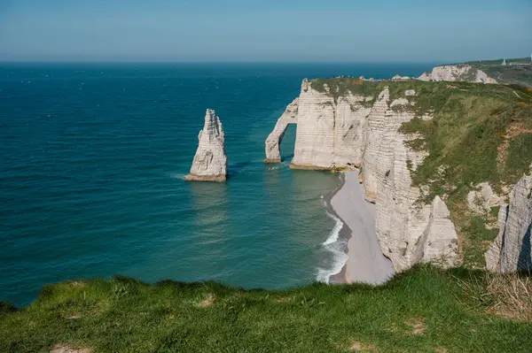 Etretat 'ın ikonik tebeşir kayalıkları ve turkuaz suları güneş ışığı altında parlayarak Normandiya' nın doğal güzelliğini ve huzurlu sahil şeridini gözler önüne seriyor..
